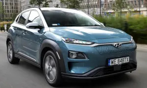 Niebieski Hyundai Kona na drodze, z widocznymi detalami, które mogą być brane pod uwagę jako **hyundai kona wady**, np. nietypowy design przedniego grilla.