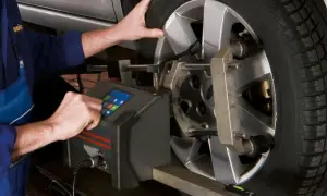Mechanik ustawia opony na maszynie do wyważania. Precyzyjne ustawienie zapewnia optymalną opony rotation.