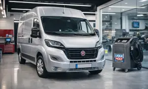 Srebrny Fiat Ducato 2.3 gotowy do serwisu. Obok maszyna do wymiany oleju Liqui Moly.