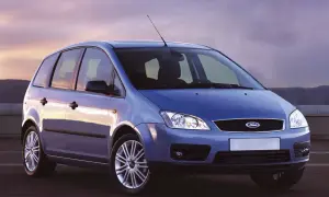 Niebieski Ford Focus C-Max z 2004 roku stoi na tle zachodzącego słońca.