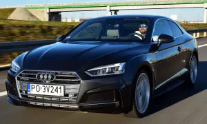 Czarny Audi A5 F5 z kierowcą w okularach przeciwsłonecznych jedzie autostradą.