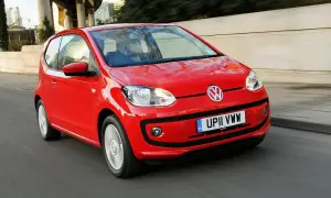 Czerwony Volkswagen Up w ruchu miejskim. Choć jego kompaktowe wymiary to zaleta, warto rozważyć potencjalne volkswagen up wady, jak ograniczona przestrzeń.