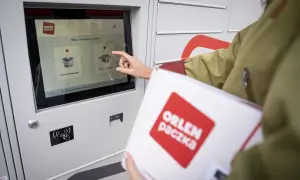 Kobieta z paczką ORLEN Paczka dotyka ekranu automatu paczkowego, wybierając opcję nadania przesyłki.
