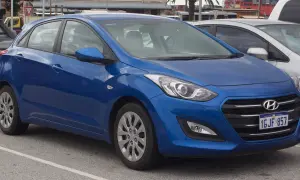 Niebieski Hyundai i30 na parkingu. Widoczne felgi i opony, które sugerują standardowy rozmiar dla tego modelu.