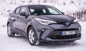 Szary Toyota C-HR na śniegu, gotowy na zimowe wyzwania.