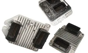 Trzy moduły sterujące silnika, jeden z nich z kodem błędu DTC P0110 Renault, gotowe do naprawy.