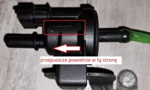Zawór podciśnienia, potencjalna przyczyna DTC P0172 w Volkswagen. Strzałka wskazuje kierunek przepływu powietrza.