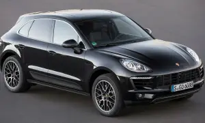 Czarny Porsche Macan na ciemnym tle. Choć piękny, warto znać jego potencjalne wady przed zakupem.