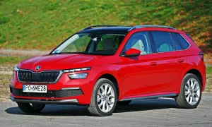 Czerwona Skoda Kamiq na tle zieleni. Zwróć uwagę na jej kompaktowe skoda kamiq wymiary, idealne do miasta.
