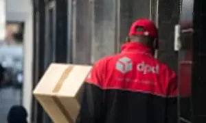 Kurier DPD z paczką przy drzwiach. Brak kodu odbioru na przesyłce.