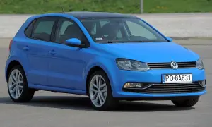 Niebieski VW Polo 2010 z czarnym dachem, zaparkowany na zewnątrz.