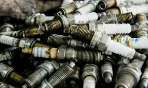 Stos zużytych świec zapłonowych, niektóre z oznaczeniem p0302, gotowe do recyklingu.