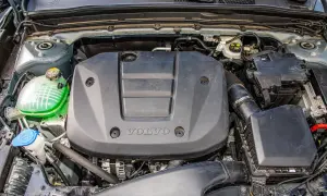 Silnik Volvo T3 z widocznym zielonym płynem w zbiorniczku i czarną osłoną z logo.