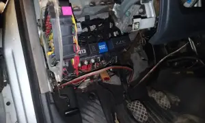 Audi A4 B6 bezpieczniki pod maską. Widoczne przewody i skrzynka z bezpiecznikami, przygotowanie do naprawy.