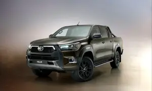 Brązowy Toyota Hilux Invincible z czarnymi felgami i relingami, gotowy na każde wyzwanie.
