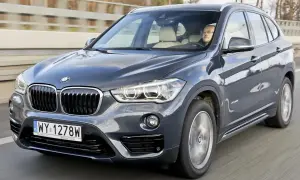 Ciemnoszary BMW X1 2020 na drodze, z kierowcą za kierownicą.