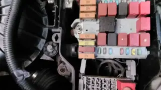 Skrzynka bezpieczników w Peugeot, potencjalny problem z dtc p1351. Widać bezpieczniki i przekaźniki.