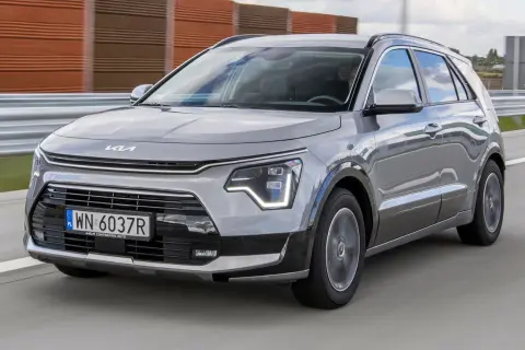 Szary Kia Niro w ruchu drogowym. Wady tego modelu mogą dotyczyć np. wyciszenia kabiny lub dynamiki.