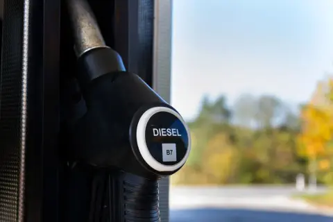Dystrybutor paliwa z oznaczeniem DIESEL B7, sugerującym zawartość biodiesla. Tło rozmyte, jesienne drzewa.