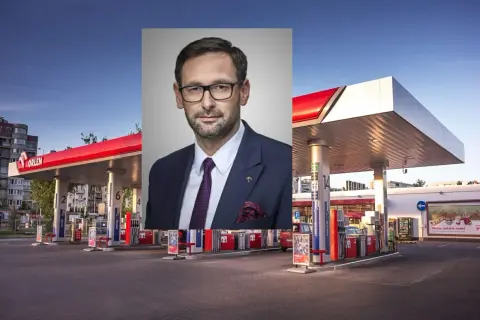 Mężczyzna w garniturze na tle stacji paliw ORLEN. Dostępne paliwo VERVA.