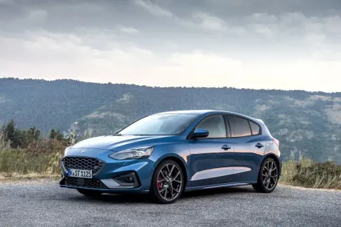 Niebieski Ford Focus MK3 ST na tle gór. Zwróć uwagę na sportowe felgi i opony, które podkreślają jego dynamikę.