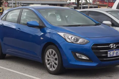Niebieski Hyundai i30 na parkingu. Widoczne felgi i opony, które sugerują standardowy rozmiar dla tego modelu.