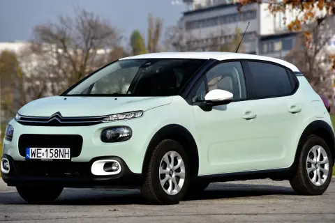 Jasnozielony Citroen C3 z białym dachem, na którym opony wyglądają na zimowe. Idealny do miasta, ale jakie opony wybrać na dalsze trasy?