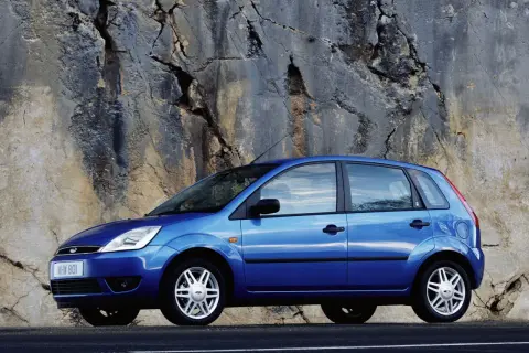 Niebieski Ford Fiesta MK5 zaparkowany przy skalnej ścianie.