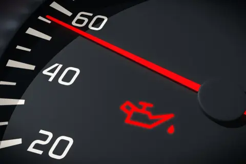 Czerwona kontrolka oleju świeci się na desce rozdzielczej, sygnalizując niski poziom lub problem z smarowaniem.