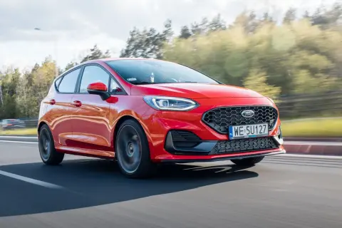 Czerwony Ford Fiesta w ruchu, widoczne felgi i opony. Rozmiar opon jest kluczowy dla osiągów.