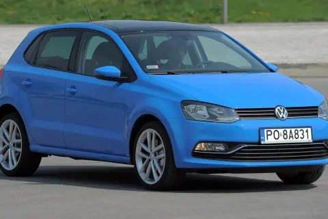 Niebieski VW Polo 2010 z czarnym dachem, zaparkowany na zewnątrz.