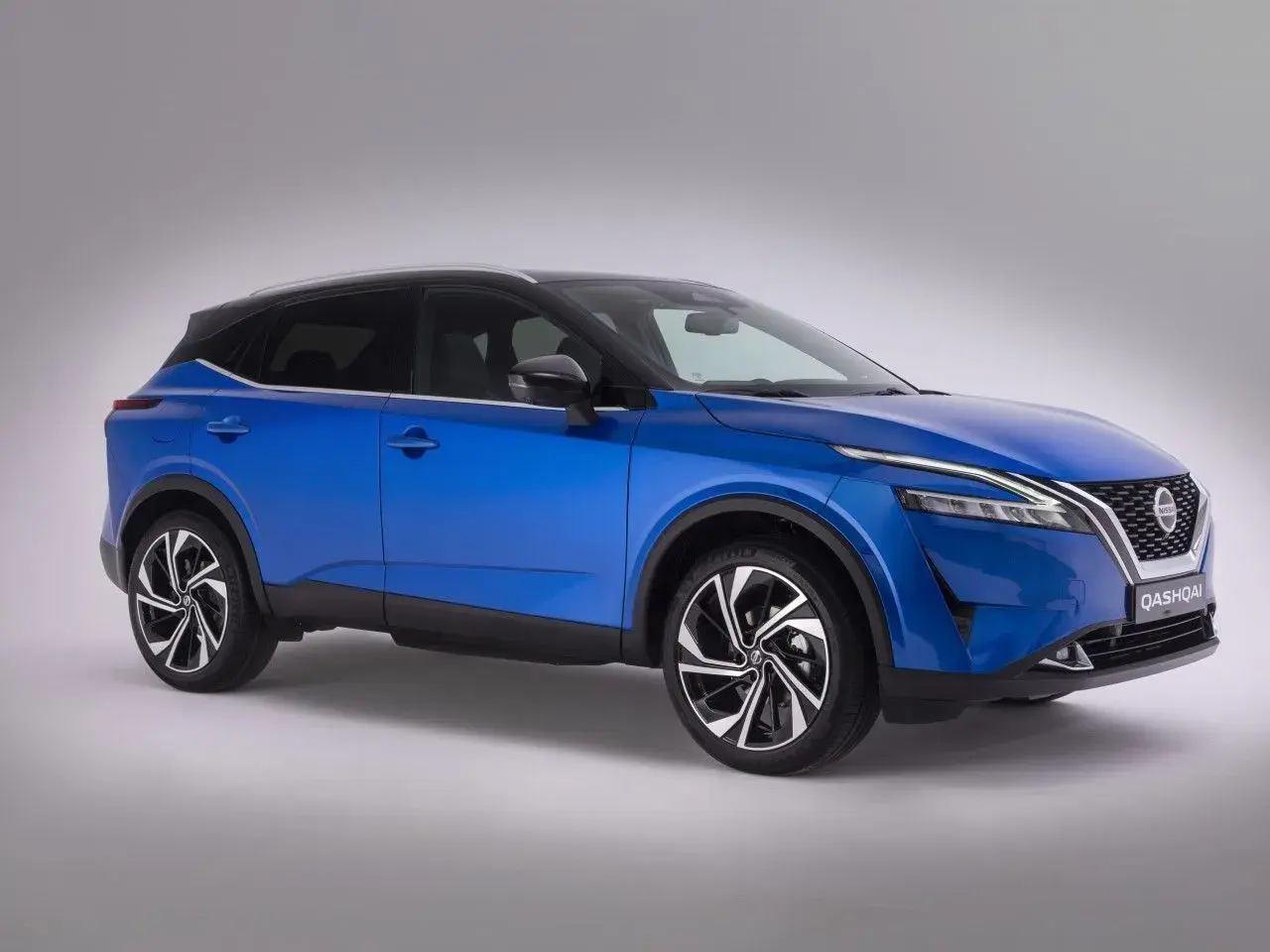 Niebieski Nissan Qashqai z dwukolorowymi felgami, na których widoczny jest rozmiar opon.