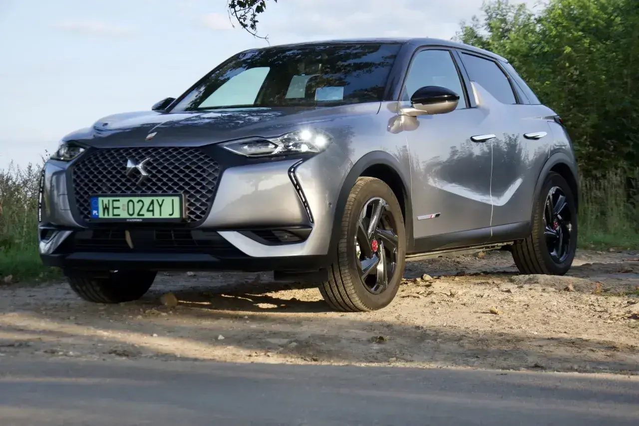 Srebrny DS3 Crossback na drodze gruntowej, z zieloną tablicą rejestracyjną.