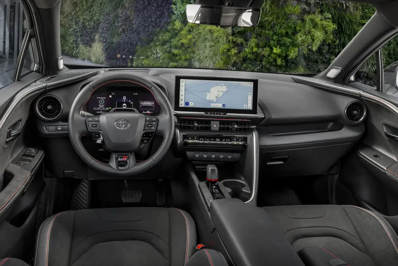 Wnętrze Toyoty CHR z ekranem nawigacji, cyfrowymi zegarami i sportową kierownicą GR.