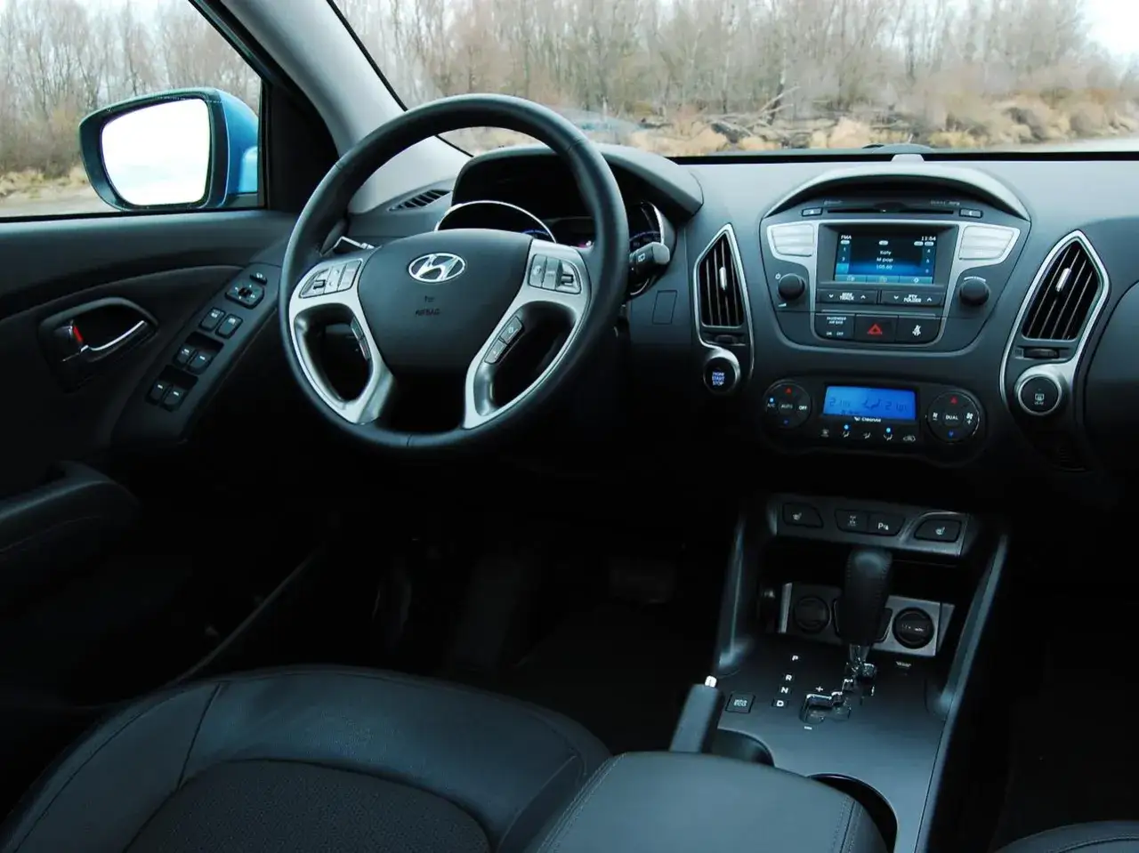Wnętrze Hyundai ix35 2.0 benzyna: kierownica, deska rozdzielcza z radiem i klimatyzacją, dźwignia zmiany biegów.