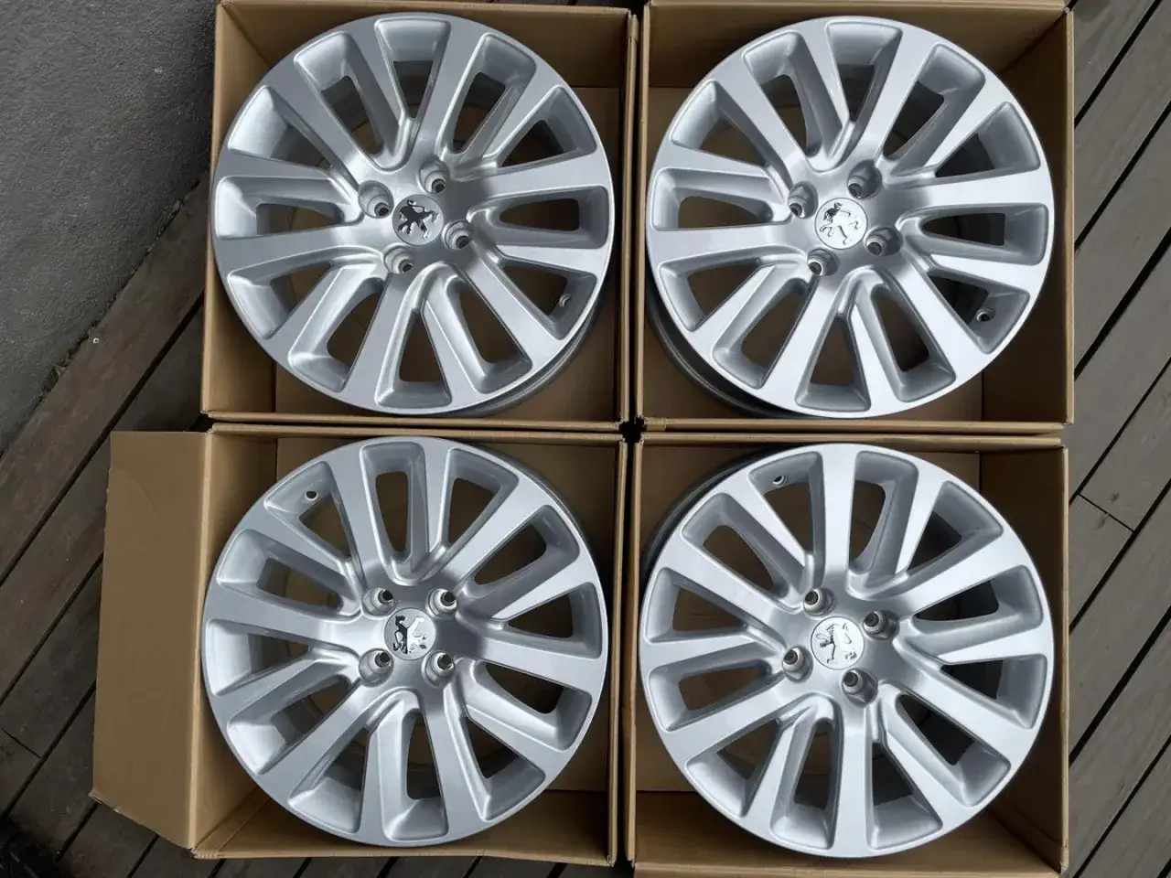 Cztery nowe felgi aluminiowe do Peugeot 407 w kartonach. Idealne, by sprawdzić, jakie opony będą pasować.