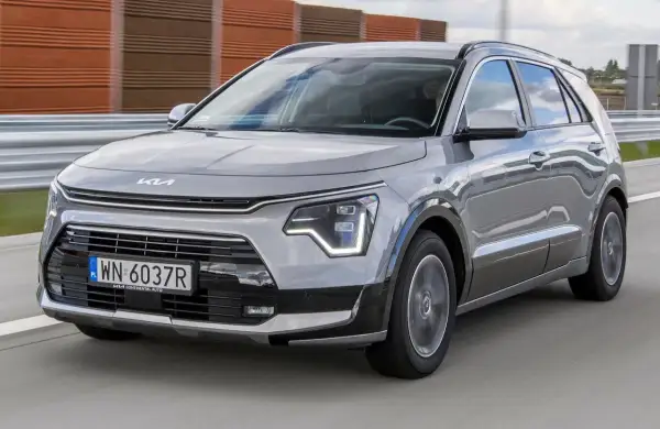 Szary Kia Niro w ruchu drogowym. Wady tego modelu mogą dotyczyć np. wyciszenia kabiny lub dynamiki.