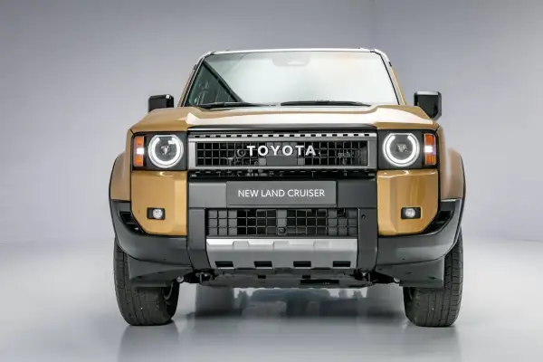 Złoty Toyota Land Cruiser 2020 z okrągłymi światłami i napisem "NEW LAND CRUISER" na grillu.