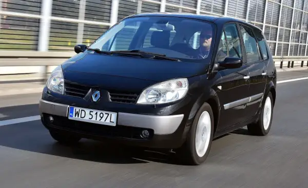 Czarny Renault Scenic 2 1.6 16v na drodze. Kierowca w okularach przeciwsłonecznych.