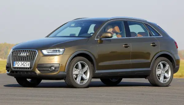 Brązowy Audi Q3 8U z brązową tapicerką, kierowca w tle.