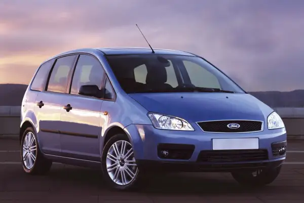 Niebieski Ford Focus C-Max z 2004 roku stoi na tle zachodzącego słońca.