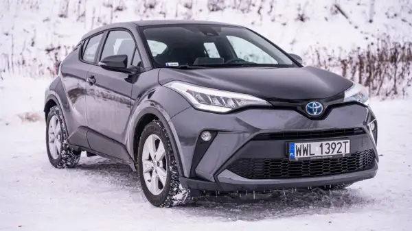 Szary Toyota C-HR na śniegu, gotowy na zimowe wyzwania.