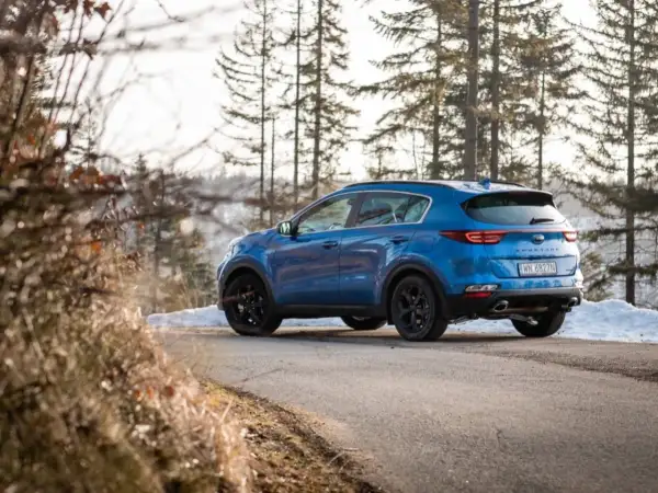 Niebieski Kia Sportage 3 na zimowej drodze. Zastanawiasz się, jakie opony do Kia Sportage 3 będą najlepsze?