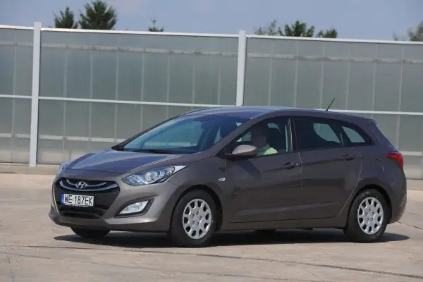 Szary Hyundai i30 II kombi, kierowca w zielonej koszulce. Zastanawiasz się, jakie żarówki do hyundai i30 ii wybrać?