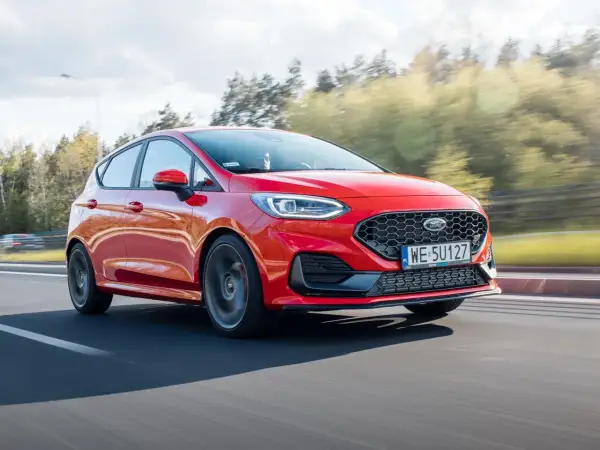 Czerwony Ford Fiesta w ruchu, widoczne felgi i opony. Rozmiar opon jest kluczowy dla osiągów.