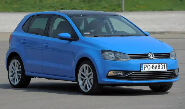Niebieski VW Polo 2010 z czarnym dachem, zaparkowany na zewnątrz.