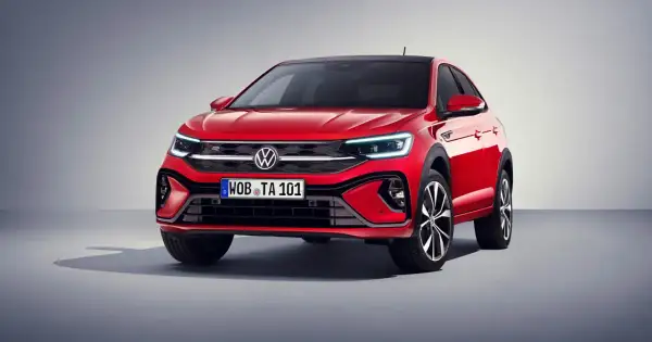 Czerwony Volkswagen Taigo z czarnym dachem prezentuje się dynamicznie. Eleganckie linie i nowoczesne światła podkreślają jego sportowy charakter.