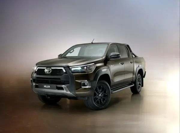 Brązowy Toyota Hilux Invincible z czarnymi felgami i relingami, gotowy na każde wyzwanie.